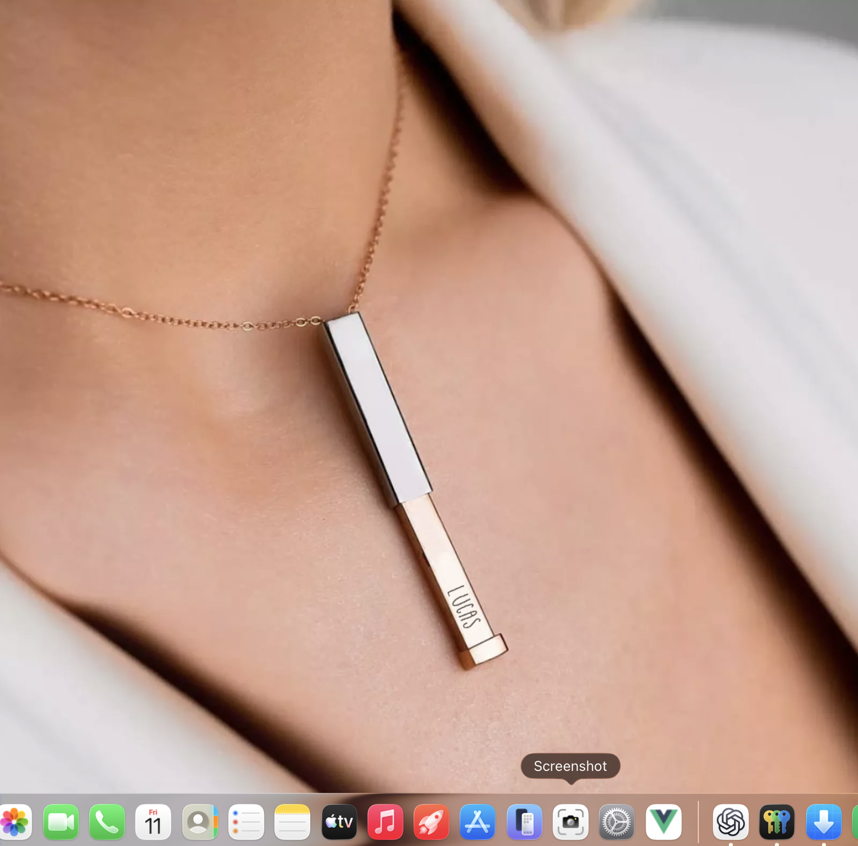Hidden Message Bar Necklace worn with the inner bar slid out to reveal the engraved name Lucas